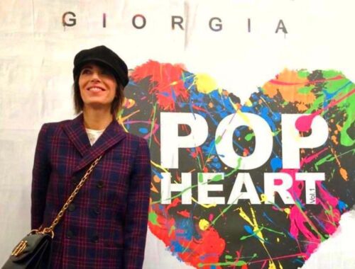 Un ritratto di Giorgia di fronte all'immagine di copertina dell'album "Pop Heart", in cui l'artista ha preferito seguire il cuore invece che la ragione